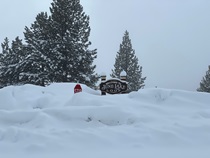The sign at June Lake is nearly buried under many feet of snow on January 11, 2023.
