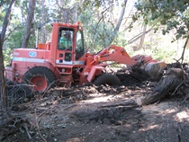 A Caltrans loader works to clear debris in Independence following flooding in July, 2008.