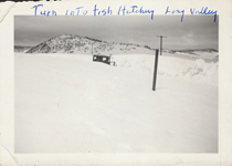 An undated image for a barely visible car surrounded by snow near the turn into Fish Hatchery in Long Valley. Writing on the image reads "Turn into Fish Hatchery. Long Valley."