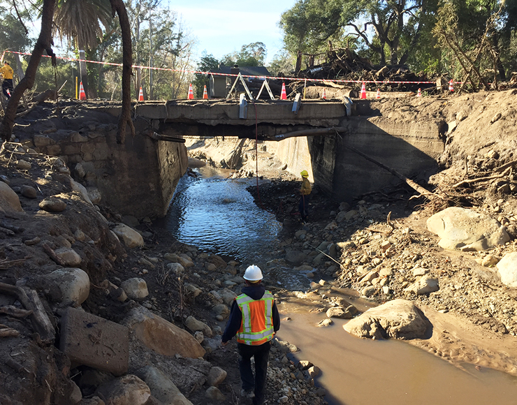 Photo shows construction crews dismantling an old bridge